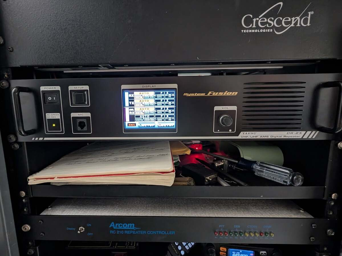 Front of the NY7S equipment rack showing the Yaesu DR-2X repeater, Arcom controller, and supporting radio equipment.